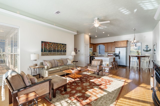 129 Lakeshore Dr, Onalaska, TX 77360 - living room featuring a ceiling fan, dark wood-type flooring, and a chandelier