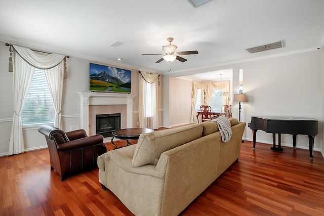 9706 Broadley Dr, Sugar Land, TX 77498 - living room featuring crown molding, healthy amount of natural light, a ceiling fan, wood finished floors, and a tile fireplace