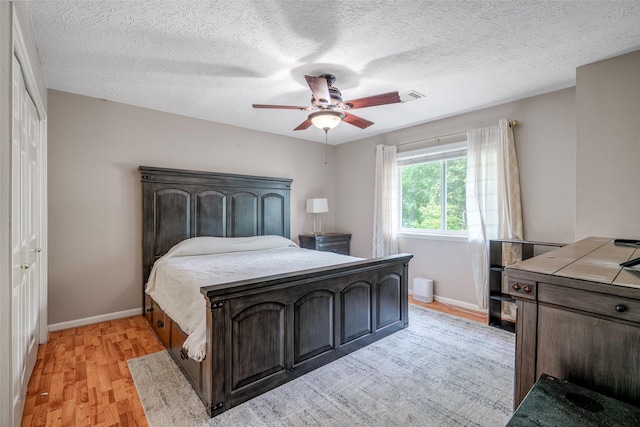9706 Broadley Dr, Sugar Land, TX 77498 - bedroom featuring light wood-type flooring, a textured ceiling, and ceiling fan