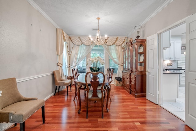 9706 Broadley Dr, Sugar Land, TX 77498 - dining space with a chandelier, ornamental molding, light wood-type flooring, and a textured ceiling