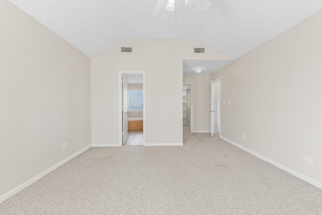 21315 Gulf Dr, Galveston, TX 77554 - unfurnished bedroom featuring a walk in closet, light colored carpet, vaulted ceiling, ensuite bath, and a ceiling fan