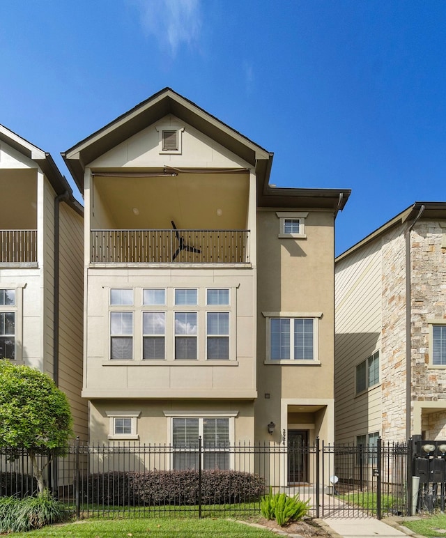 2924 Leeland St, Houston, TX 77003 - view of front of house featuring stucco siding, a balcony, and a fenced front yard