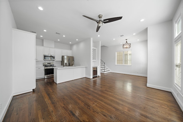 2924 Leeland St, Houston, TX 77003 - unfurnished living room with stairway, plenty of natural light, dark wood-style flooring, ceiling fan, and recessed lighting