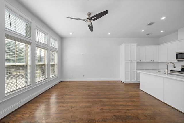 2924 Leeland St, Houston, TX 77003 - kitchen with ceiling fan, recessed lighting, stainless steel microwave, dark wood finished floors, and white cabinetry