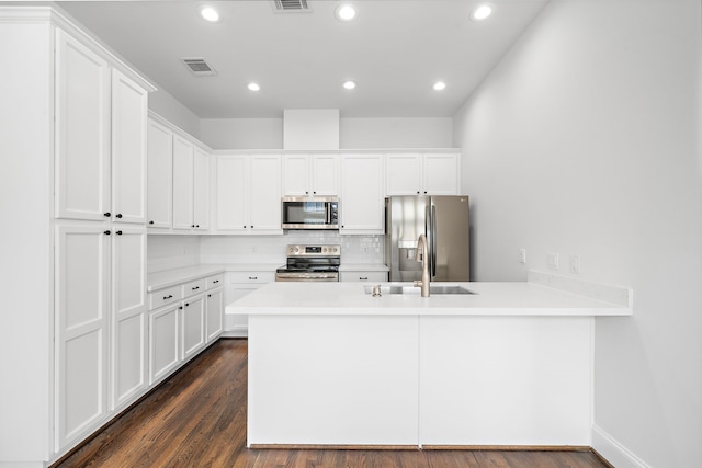 2924 Leeland St, Houston, TX 77003 - kitchen featuring stainless steel appliances, a peninsula, light countertops, white cabinets, and recessed lighting