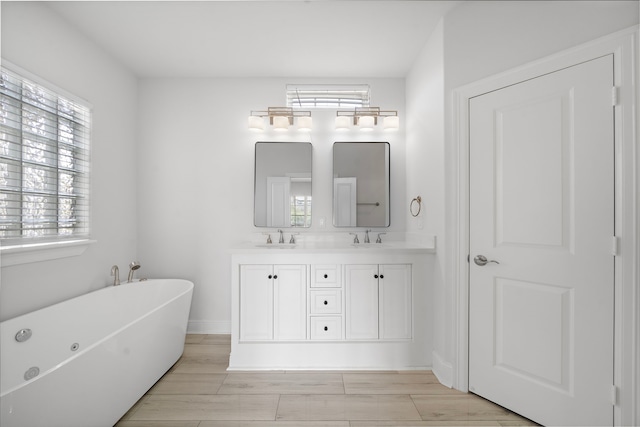 2924 Leeland St, Houston, TX 77003 - full bathroom featuring a freestanding tub, double vanity, and wood finished floors