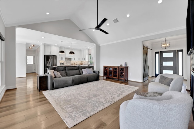110 Penguin Pt, Point Blank, TX 77364 - living area with a barn door, ceiling fan, ornamental molding, recessed lighting, and high vaulted ceiling