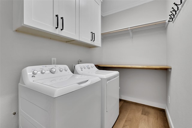110 Penguin Pt, Point Blank, TX 77364 - laundry room featuring washer and dryer, cabinet space, and light wood-style flooring