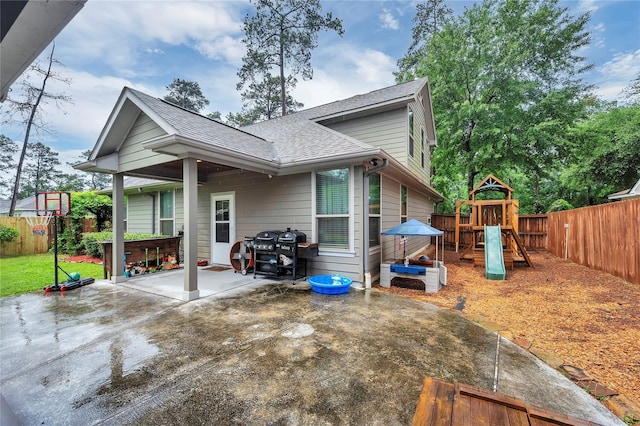 10252 Sunset Ln, Conroe, TX 77385 - back of house with a patio, a fenced backyard, a shingled roof, and a playground