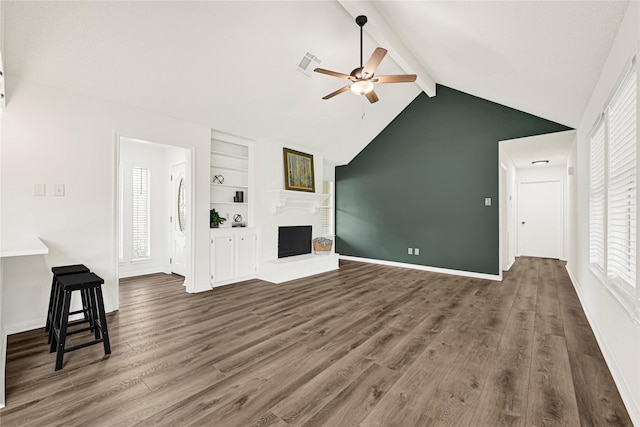 4005 Stoneybrook St, Baytown, TX 77521 - unfurnished living room with a ceiling fan, beamed ceiling, a fireplace, healthy amount of natural light, and wood finished floors