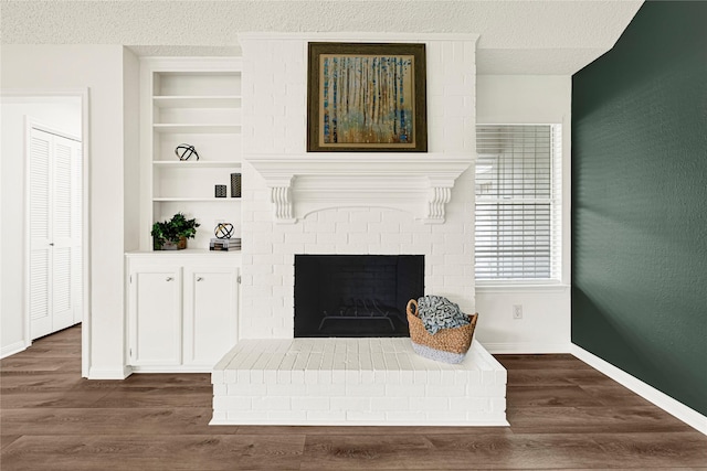 4005 Stoneybrook St, Baytown, TX 77521 - living area featuring a brick fireplace, dark wood-style floors, built in features, and a textured ceiling