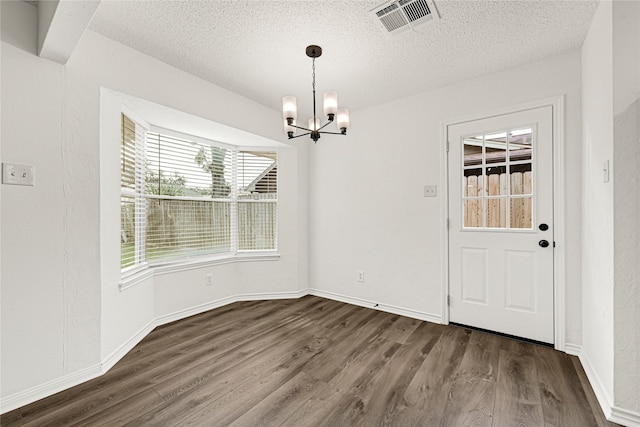 4005 Stoneybrook St, Baytown, TX 77521 - unfurnished dining area with a chandelier, wood finished floors, and a textured ceiling