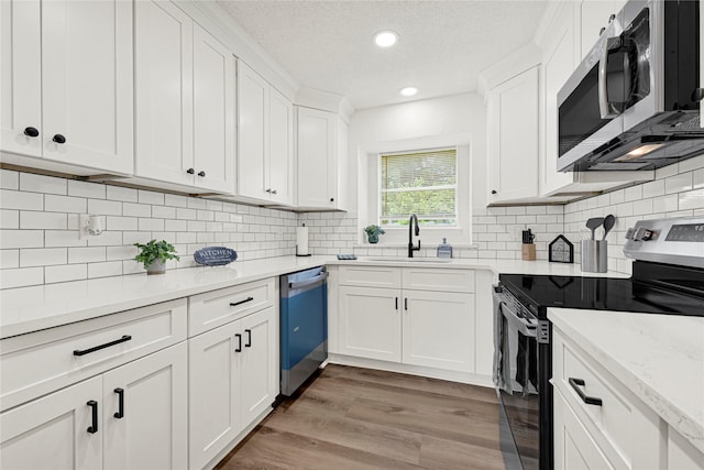 4005 Stoneybrook St, Baytown, TX 77521 - kitchen featuring stainless steel appliances, white cabinets, backsplash, recessed lighting, and a textured ceiling