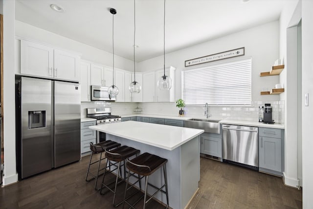 2212 Mcgowen St, Houston, TX 77004 - kitchen featuring appliances with stainless steel finishes, tasteful backsplash, dark wood-style floors, a breakfast bar area, and recessed lighting