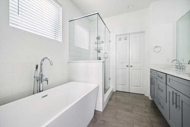 2212 Mcgowen St, Houston, TX 77004 - bathroom with a freestanding tub, a shower stall, double vanity, and tile walls