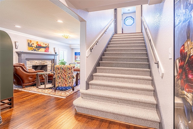 3217 Parkwood Dr, Houston, TX 77021 - staircase featuring crown molding, wood finished floors, a fireplace, arched walkways, and recessed lighting