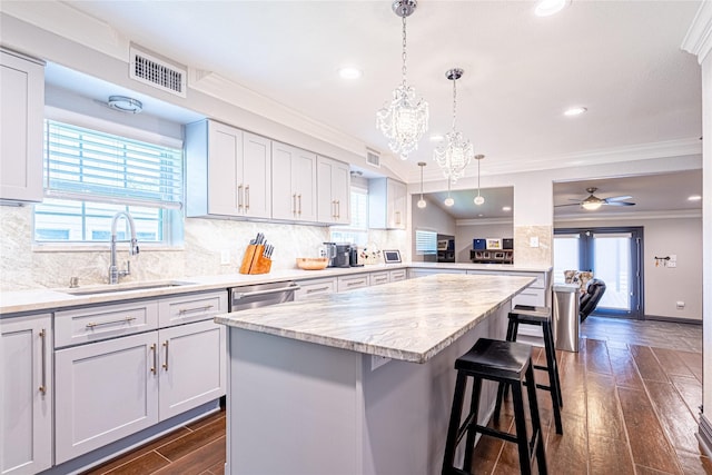 3217 Parkwood Dr, Houston, TX 77021 - kitchen with dark wood finished floors, a kitchen breakfast bar, crown molding, a kitchen island, and tasteful backsplash