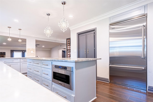 3217 Parkwood Dr, Houston, TX 77021 - kitchen with stainless steel built in fridge, light countertops, dark wood-type flooring, ornamental molding, and pendant lighting