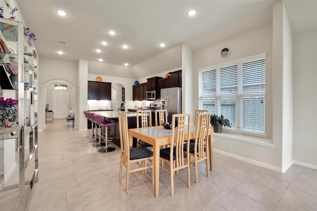 22223 Ebbets Field Dr, Spring, TX 77389 - dining space with arched walkways, recessed lighting, and light tile patterned floors