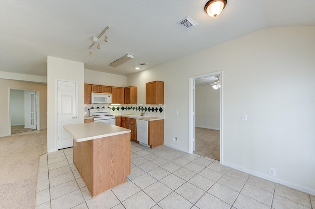 20218 Cypresswood Gln, Spring, TX 77373 - kitchen with white appliances, light countertops, a center island, light tile patterned floors, and vaulted ceiling