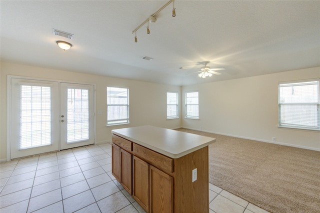 20218 Cypresswood Gln, Spring, TX 77373 - kitchen with light tile patterned floors, ceiling fan, brown cabinets, a center island, and french doors