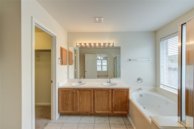 20218 Cypresswood Gln, Spring, TX 77373 - full bathroom with healthy amount of natural light, a jetted tub, double vanity, and tile patterned floors
