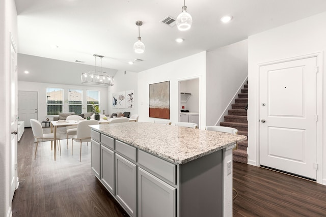 6223 Milbridge Creek Ln, Katy, TX 77493 - kitchen featuring gray cabinets, washing machine and clothes dryer, dark wood-type flooring, a center island, and hanging light fixtures
