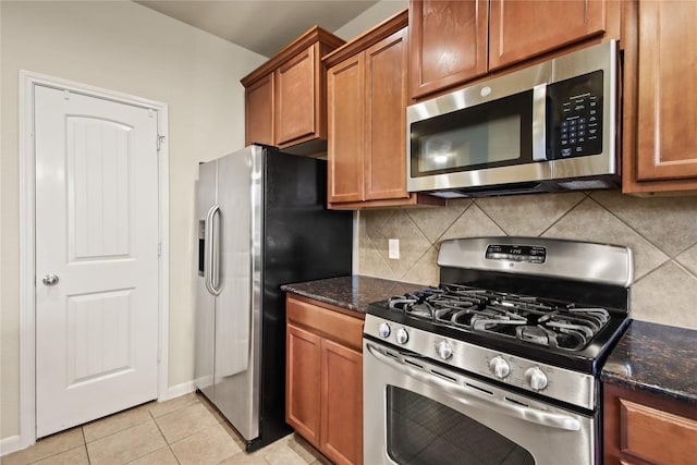 187 Black Swan Pl, The Woodlands, TX 77354 - kitchen with appliances with stainless steel finishes, brown cabinets, tasteful backsplash, and dark stone counters