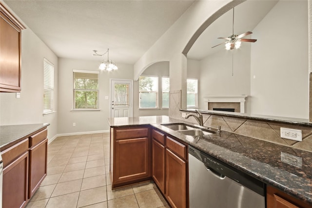 187 Black Swan Pl, The Woodlands, TX 77354 - kitchen with dishwasher, ceiling fan, light tile patterned floors, a fireplace, and dark stone countertops