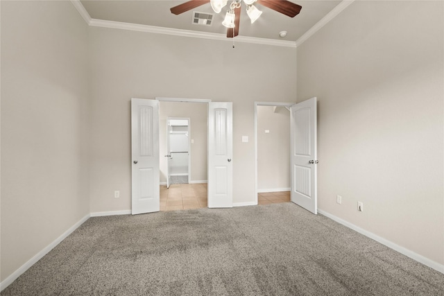 187 Black Swan Pl, The Woodlands, TX 77354 - unfurnished bedroom featuring carpet floors, ornamental molding, tile patterned flooring, a high ceiling, and a ceiling fan