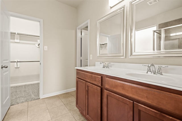 187 Black Swan Pl, The Woodlands, TX 77354 - full bath featuring double vanity, a walk in closet, tile patterned flooring, and a shower with door
