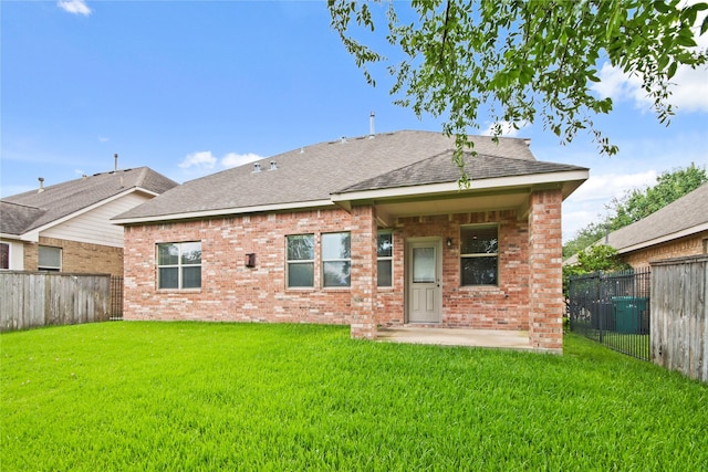 187 Black Swan Pl, The Woodlands, TX 77354 - rear view of property featuring brick siding, a fenced backyard, a shingled roof, and a patio area