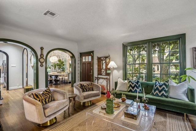 2248 Robinhood St, Houston, TX 77005 - living room with arched walkways, wood finished floors, and a textured ceiling