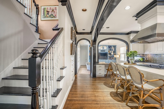 2248 Robinhood St, Houston, TX 77005 - stairway featuring ornamental molding, arched walkways, wood finished floors, and recessed lighting