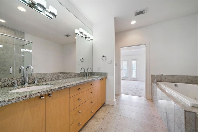 4707 Caroline St, Houston, TX 77004 - full bathroom featuring a garden tub, double vanity, a shower stall, tile patterned flooring, and recessed lighting