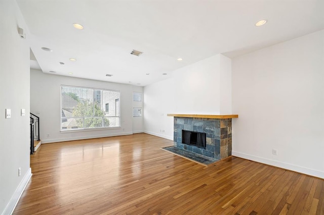 4707 Caroline St, Houston, TX 77004 - unfurnished living room with wood finished floors, a tiled fireplace, stairway, and recessed lighting