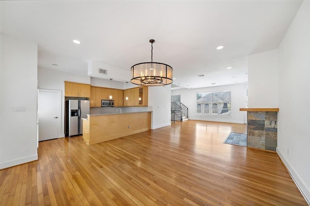 4707 Caroline St, Houston, TX 77004 - unfurnished living room featuring light wood finished floors, a chandelier, recessed lighting, and stairs