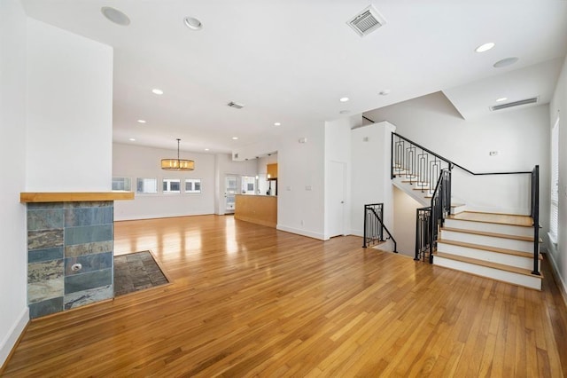 4707 Caroline St, Houston, TX 77004 - unfurnished living room with light wood-type flooring, recessed lighting, and stairs