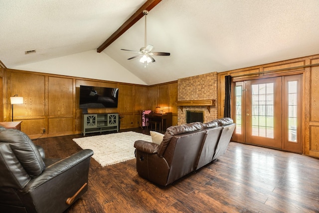 108 Laurel Valley Dr, West Columbia, TX 77486 - living room featuring wooden walls, ceiling fan, dark wood-style flooring, a brick fireplace, and a textured ceiling