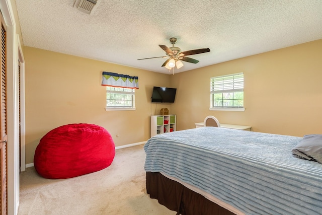 108 Laurel Valley Dr, West Columbia, TX 77486 - carpeted bedroom featuring multiple windows, a closet, a ceiling fan, and a textured ceiling