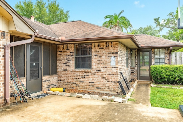 108 Laurel Valley Dr, West Columbia, TX 77486 - view of exterior entry featuring a shingled roof, brick siding, and a patio area