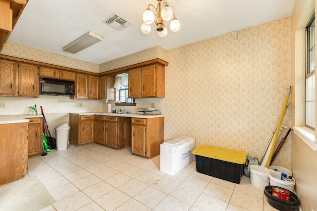 108 Laurel Valley Dr, West Columbia, TX 77486 - kitchen featuring black microwave, brown cabinets, wallpapered walls, a chandelier, and light countertops