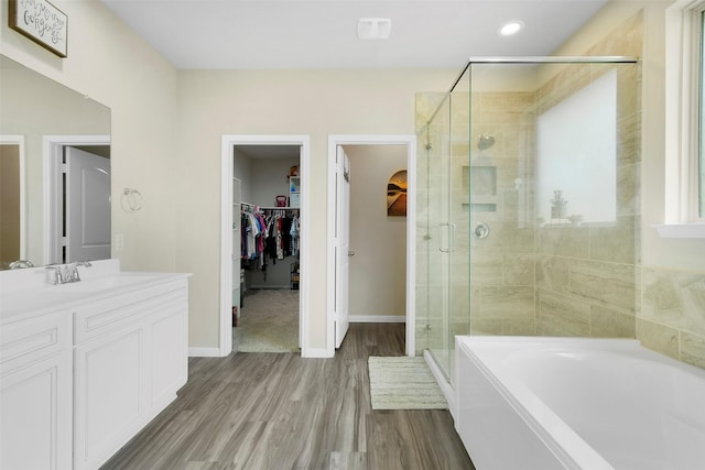 12806 Durham Creek Ln, Tomball, TX 77375 - bathroom featuring a stall shower, a walk in closet, vanity, a bath, and wood finished floors