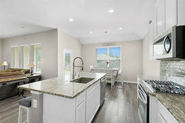 12806 Durham Creek Ln, Tomball, TX 77375 - kitchen featuring appliances with stainless steel finishes, light stone counters, tasteful backsplash, wood finished floors, and recessed lighting