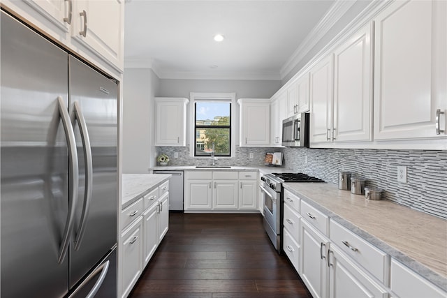 802 Malone St Unit A, Houston, TX 77007 - kitchen featuring appliances with stainless steel finishes, light countertops, white cabinets, backsplash, and ornamental molding