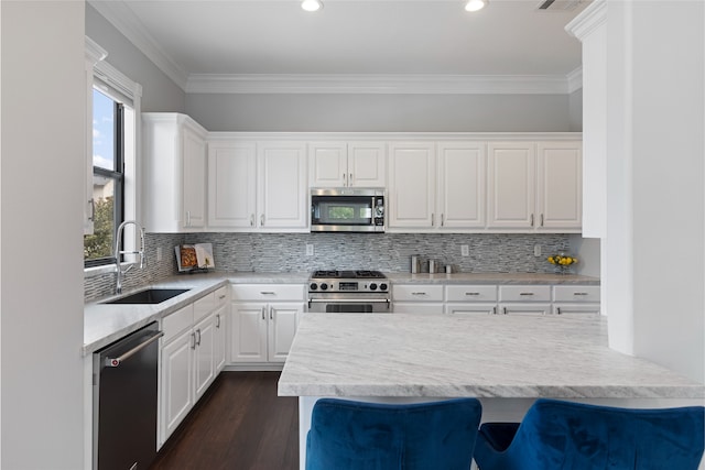 802 Malone St Unit A, Houston, TX 77007 - kitchen with appliances with stainless steel finishes, white cabinetry, ornamental molding, dark wood finished floors, and decorative backsplash