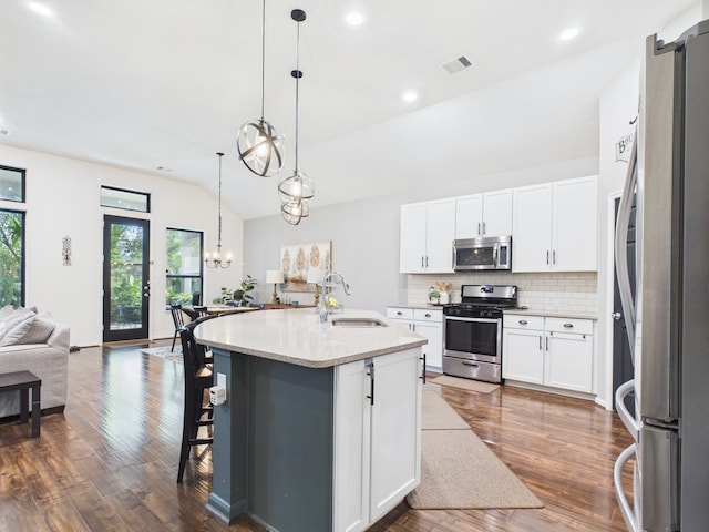 6003 Rivergrove Bend Dr, Humble, TX 77346 - kitchen with stainless steel appliances, lofted ceiling, open floor plan, tasteful backsplash, and dark wood-type flooring