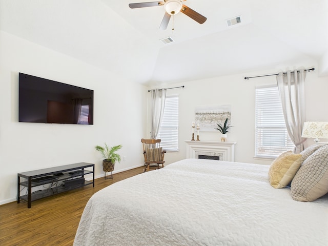 6003 Rivergrove Bend Dr, Humble, TX 77346 - bedroom featuring lofted ceiling, dark wood finished floors, multiple windows, a ceiling fan, and a fireplace