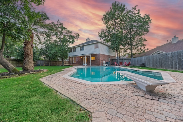 3307 La Seine Ln, Spring, TX 77388 - pool at dusk featuring a diving board, a fenced backyard, and a patio area