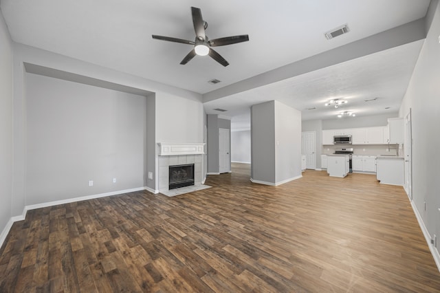 3307 La Seine Ln, Spring, TX 77388 - unfurnished living room with ceiling fan, wood finished floors, and a tiled fireplace